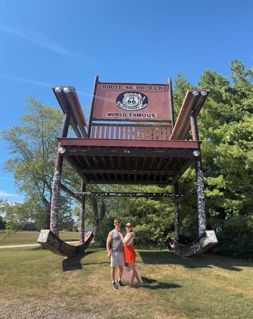 Luciana e Ebert sob a cadeira gigante no Fanning Outpost General Store, Cuba, Missouri